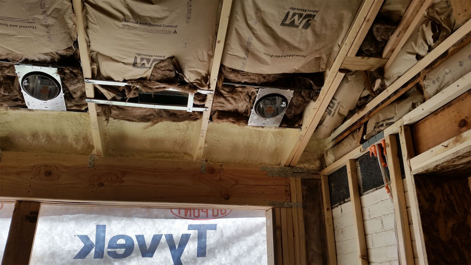 Insulated floor framing and can light housings in a Denver home addition