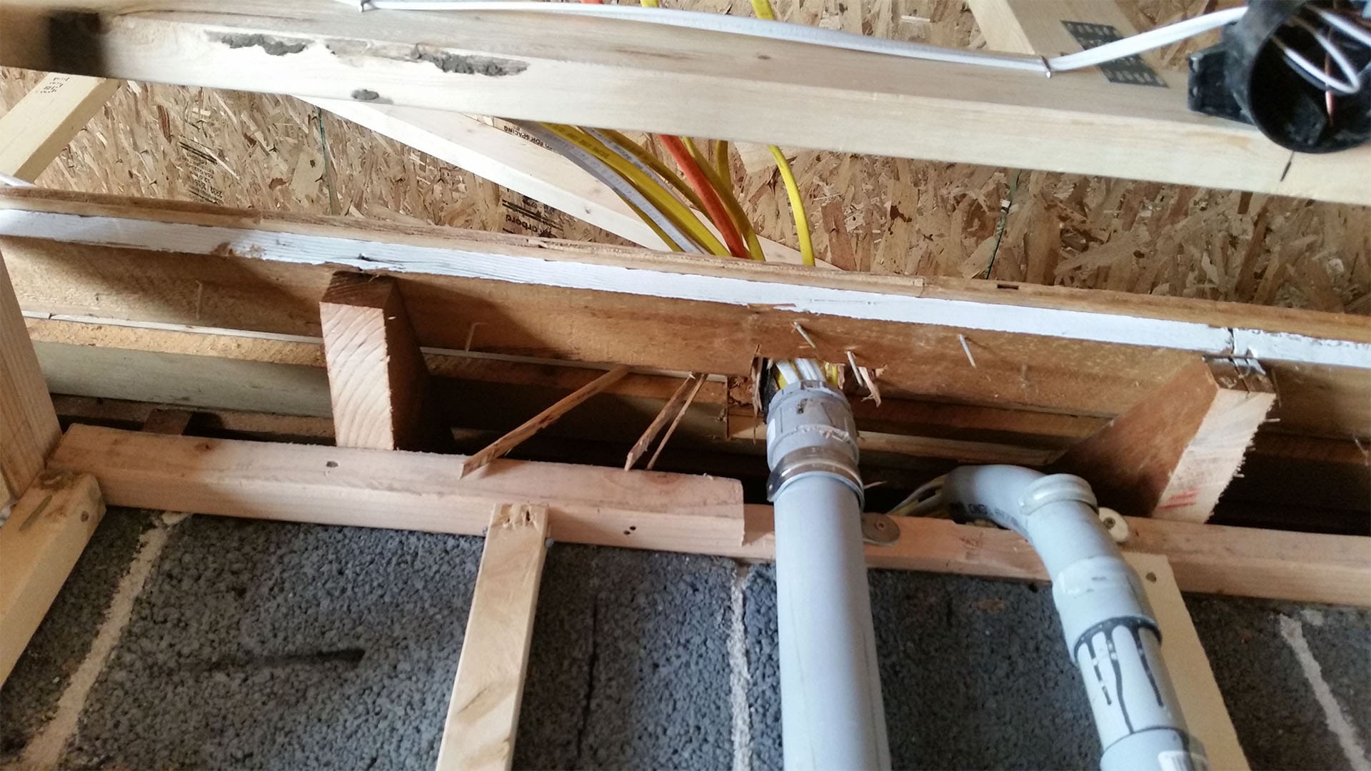 Drain and vent plumbing run through the floor framing of a Denver home addition
